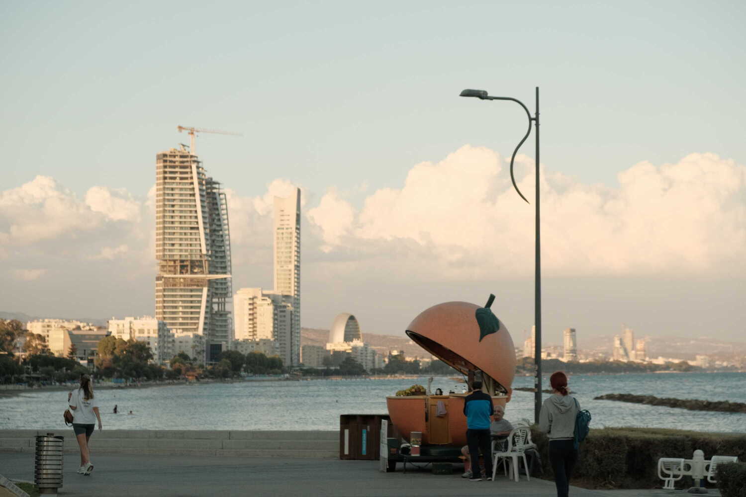Photo of a an orange fruit shaped store in front of the coast in Limassol, Cyprus
